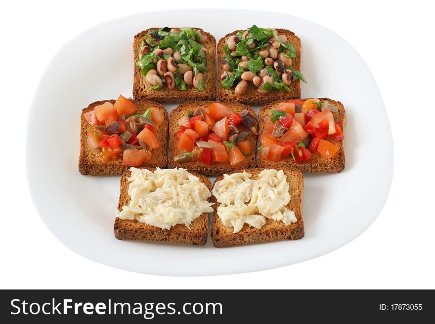 Toasts with cut tomato with olives, beans with basil and codfish. Toasts with cut tomato with olives, beans with basil and codfish