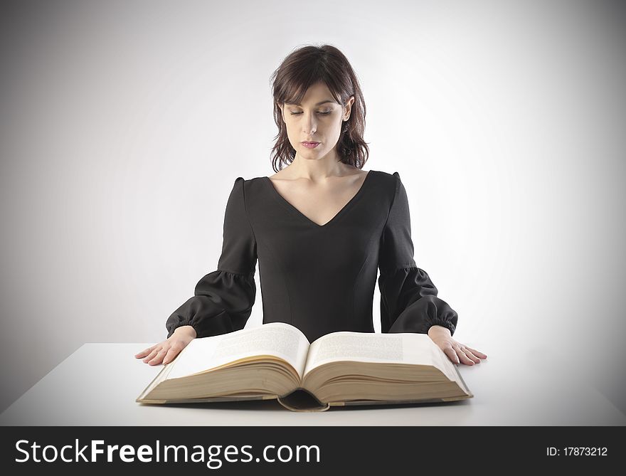 Young woman reading a thick book. Young woman reading a thick book