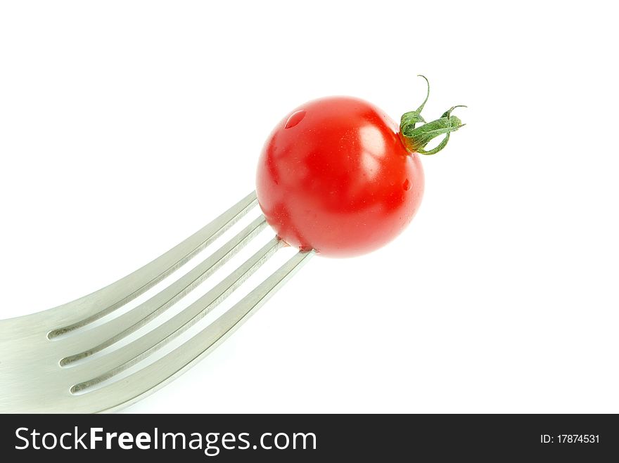 Fresh tomato on the fork on white