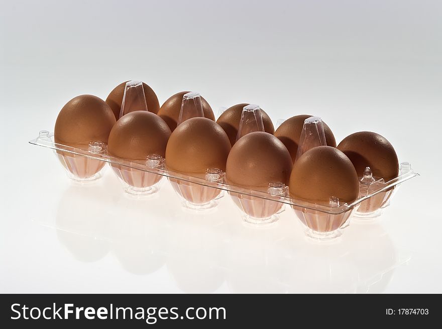 Eggs in a plastic container on white background