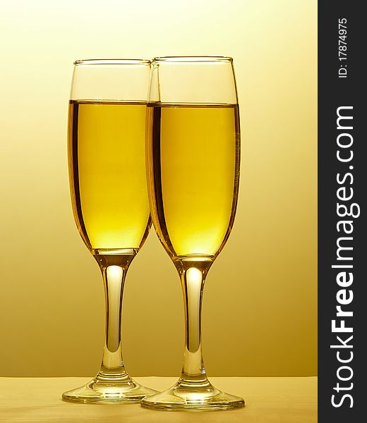 Sparkling wine in two glasses clinked in toast to celebrate event. Isolated on white. Sparkling wine in two glasses clinked in toast to celebrate event. Isolated on white.