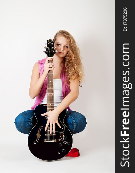 Young girl with a guitar on a white background