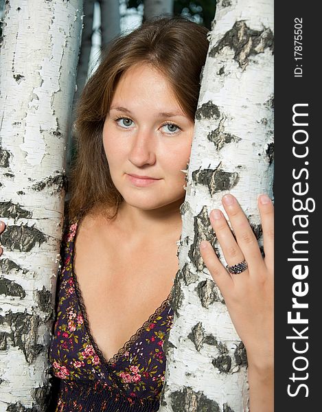 Attractive young tired woman near by birch