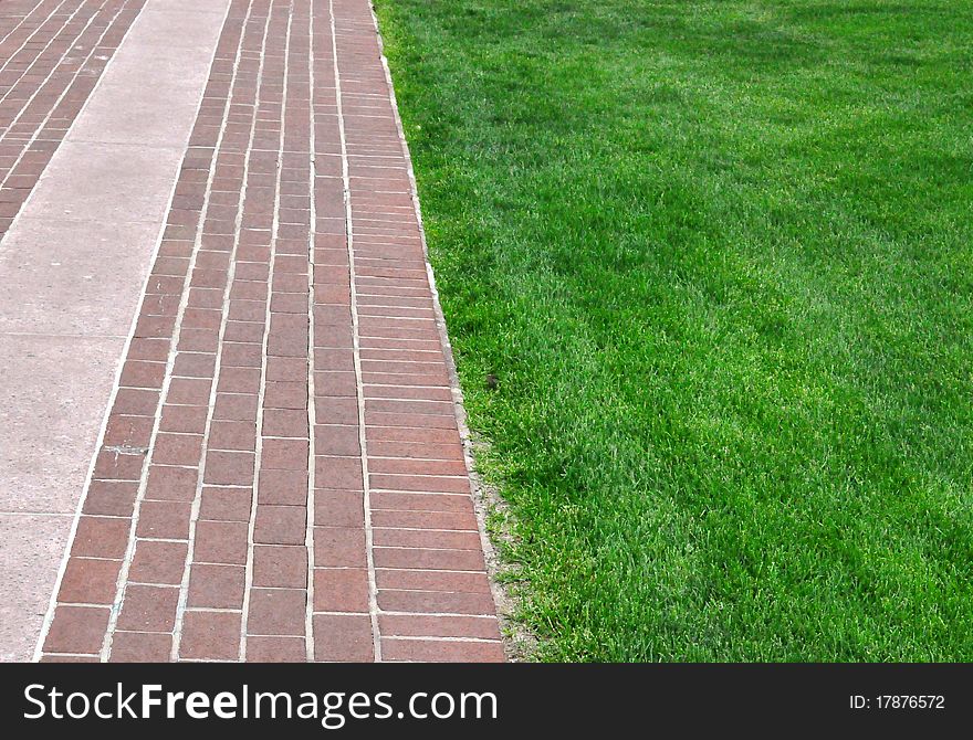 Brick pathway along green grass - background