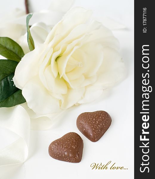 Two chocolate hearts with white flower on background. With simple text. Two chocolate hearts with white flower on background. With simple text