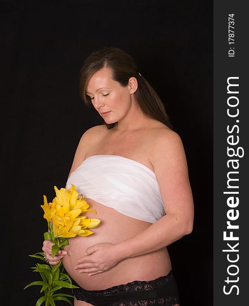 Pregnant lady with yellow flowers and black background. Pregnant lady with yellow flowers and black background
