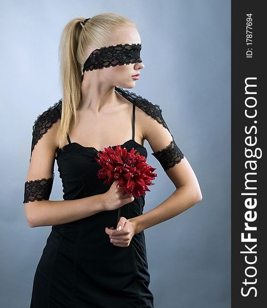 Emotional blonde girl with closed eyes and red flower at hand. Emotional blonde girl with closed eyes and red flower at hand