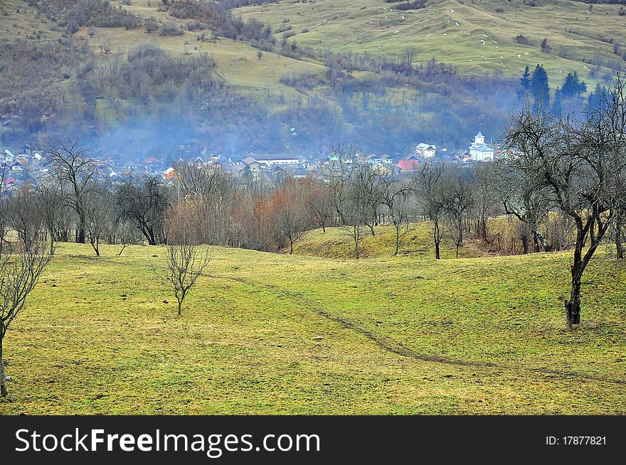 Fog over valley village with orchard