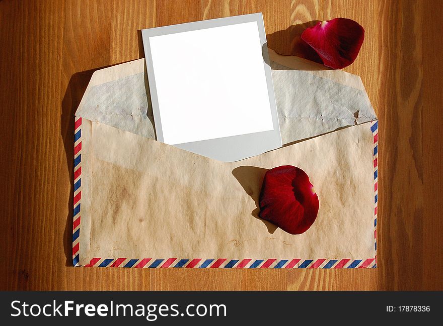 Love letter with rose petals and a blank photograph. Love letter with rose petals and a blank photograph