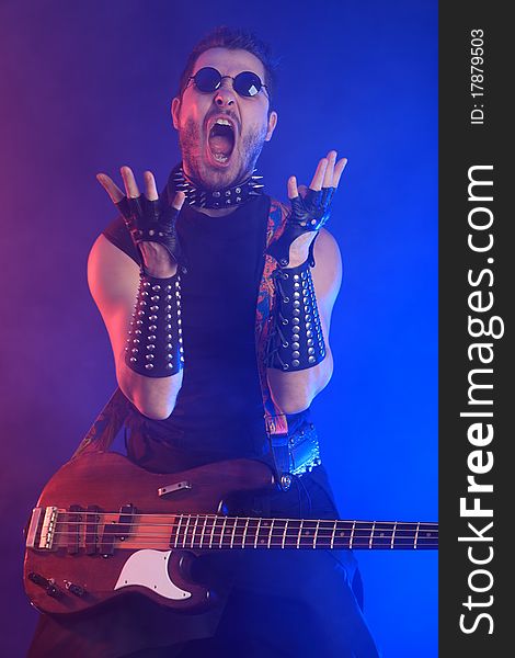 Heavy metal musician is playing electrical guitar. Shot in a studio. Heavy metal musician is playing electrical guitar. Shot in a studio.