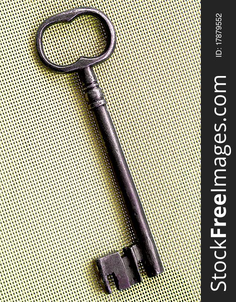 Old wrought-iron key on ayellowish background. Old wrought-iron key on ayellowish background