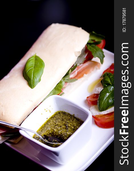 Long baguette sandwich with ham, fresh vegetables and pesto. Long baguette sandwich with ham, fresh vegetables and pesto