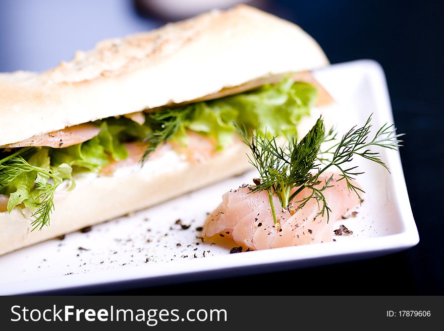 Long baguette sandwich with salmon and fresh vegetables. Long baguette sandwich with salmon and fresh vegetables