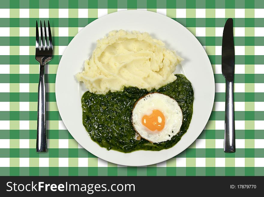 Spinach with egg and mashed potatoes and cutlery