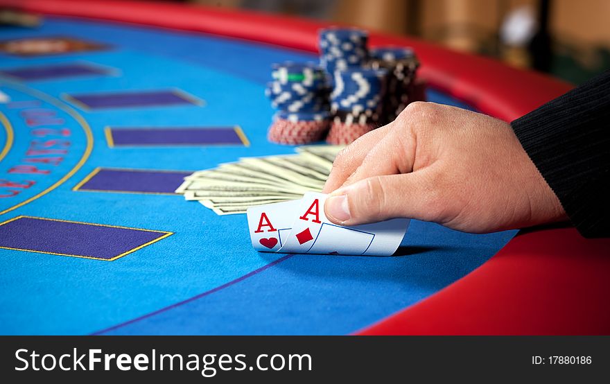 Hand with chips, and $ banknotes on table