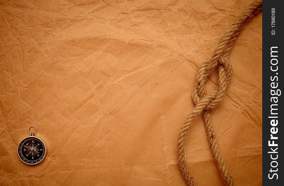 Compass and rope on old yellow paper