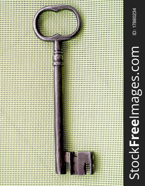 Old wrought-iron key on ayellowish background. Old wrought-iron key on ayellowish background