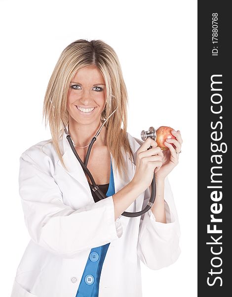 A woman doctor is holding a stethoscope to an apple. A woman doctor is holding a stethoscope to an apple.