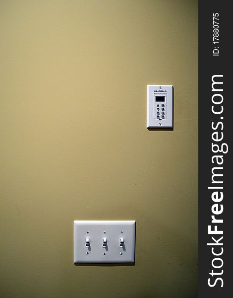 A wall mounted light switch and electronic fire place switch in a home. A wall mounted light switch and electronic fire place switch in a home.