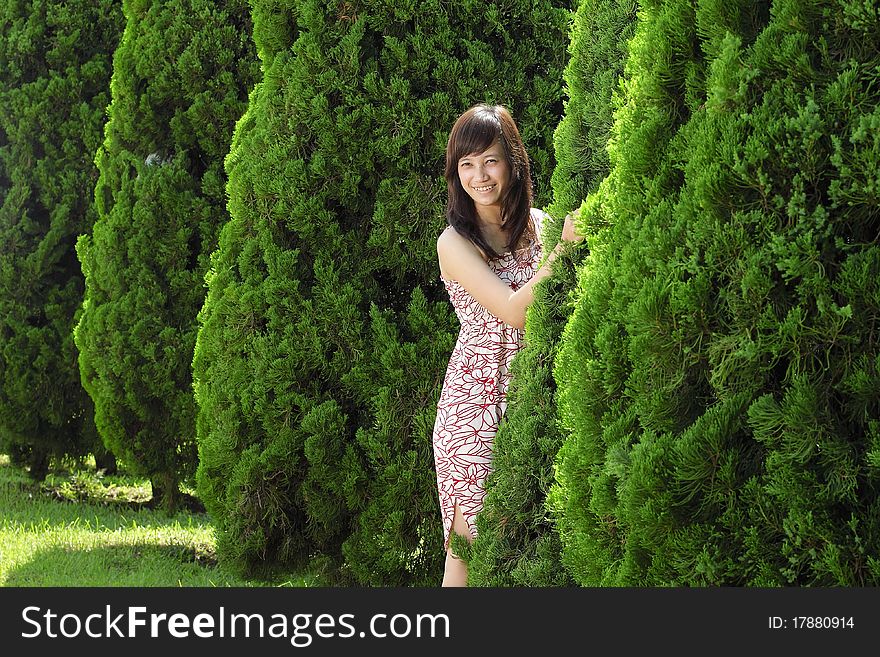 Young beautiful girl smiling outdoor near pine tree. Young beautiful girl smiling outdoor near pine tree