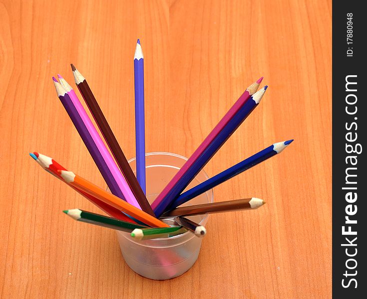 Pencils in glass on wood background. Pencils in glass on wood background