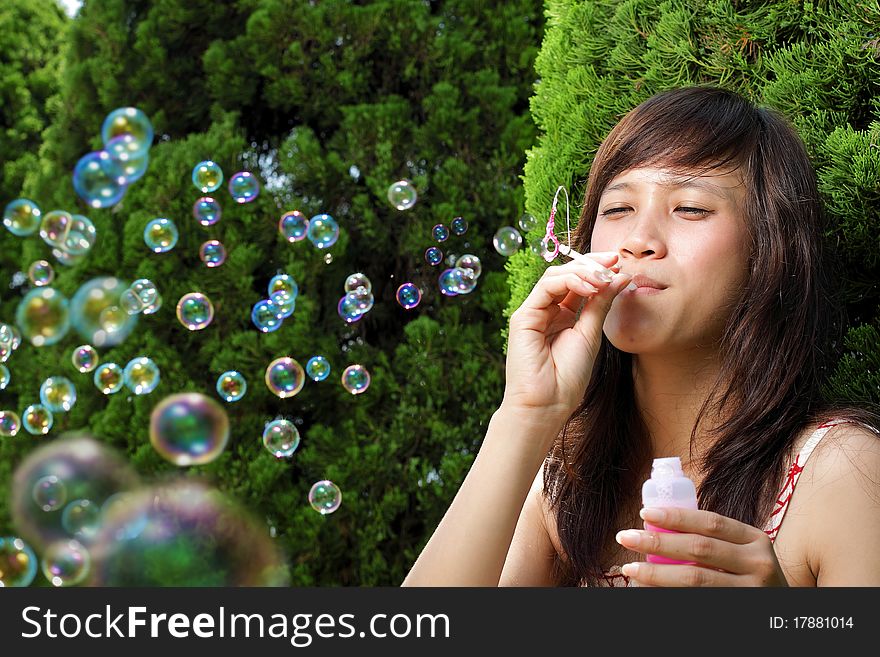 Young beautiful girl smiling outdoor play with bubble soap. Young beautiful girl smiling outdoor play with bubble soap