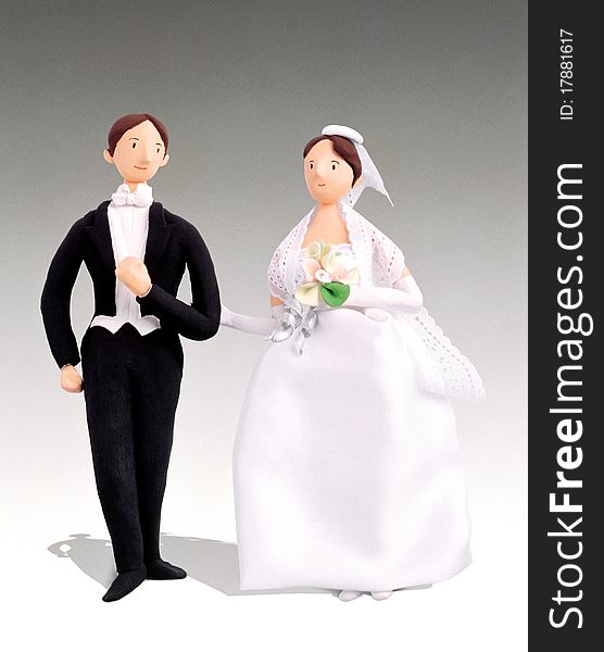 A pair of male and female figurines in wedding attire. A pair of male and female figurines in wedding attire.
