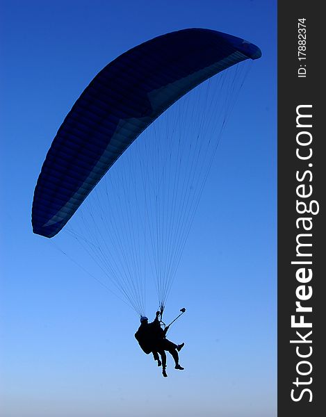 Silhouette of paraglider against deep blue sky. Silhouette of paraglider against deep blue sky