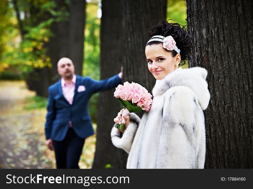 Joyful bride and groom in park on wedding walk