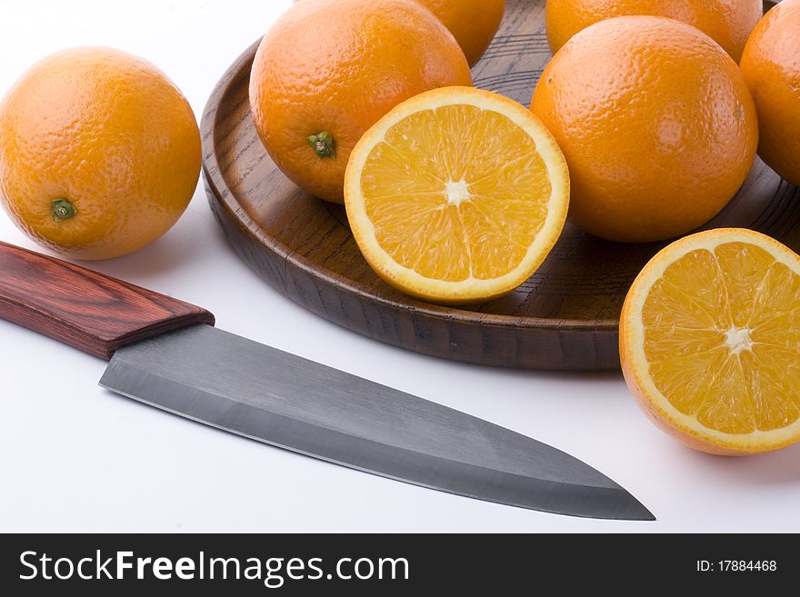 Oranges and knives on plate