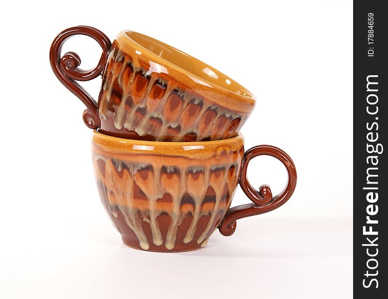 Large stack of ceramic tea cups closeup, isolated on a white background