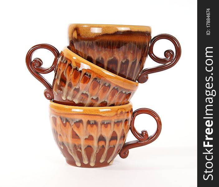 Large stack of ceramic tea cups closeup, isolated on a white background