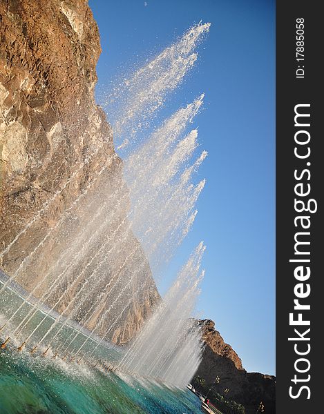 An angled shot from a series of fountains springing water forming a water wall. MUSCAT, OMAN. An angled shot from a series of fountains springing water forming a water wall. MUSCAT, OMAN
