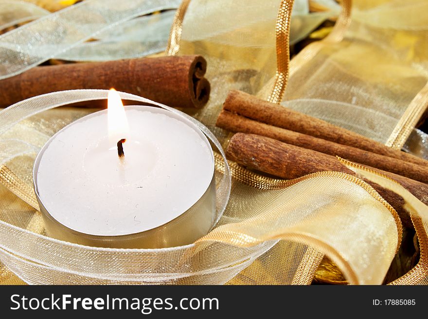 Candle on random background with ribbons and cinnamon. Candle on random background with ribbons and cinnamon