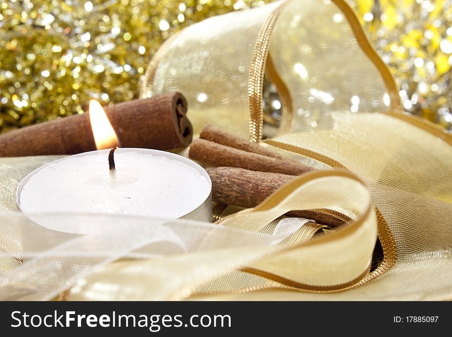 Candle on random background with ribbons and cinnamon. Candle on random background with ribbons and cinnamon