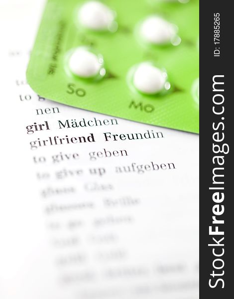 The word girl in selective focus with birth control pill. The word girl in selective focus with birth control pill