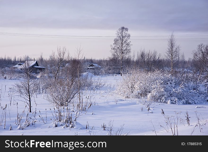 Winter rural landscape with snow and ice-covered grass