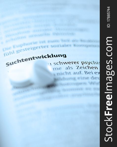 Book with word addiction and pills ( german) selective focus