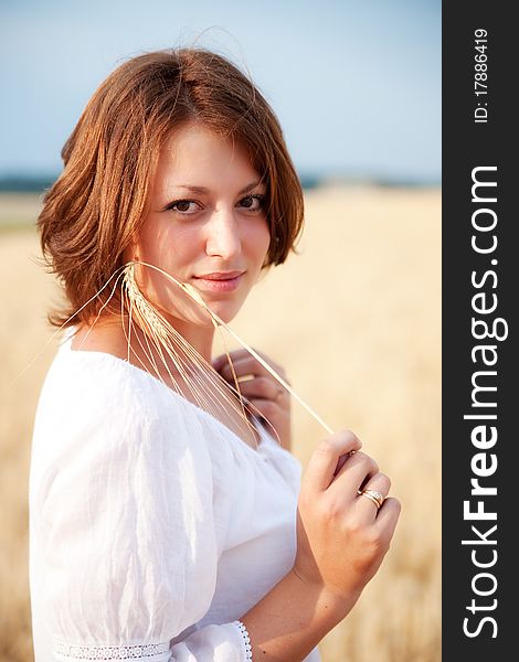 Beautiful young woman standing in wheat field. Beautiful young woman standing in wheat field