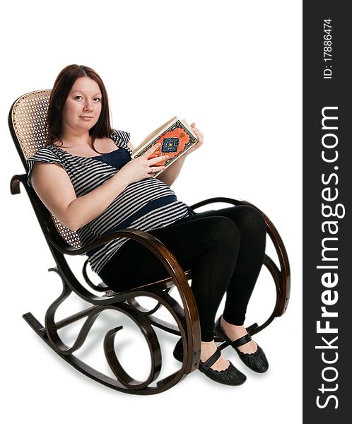 Pregnant woman reading a book in a rocking chair, isolated on white