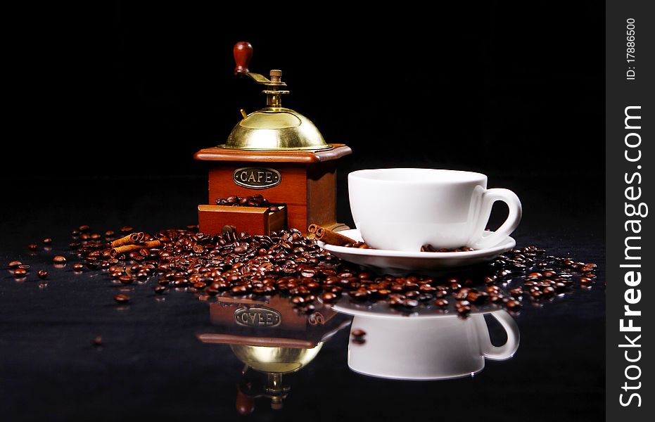 Coffee mill on the table with coffee beans around