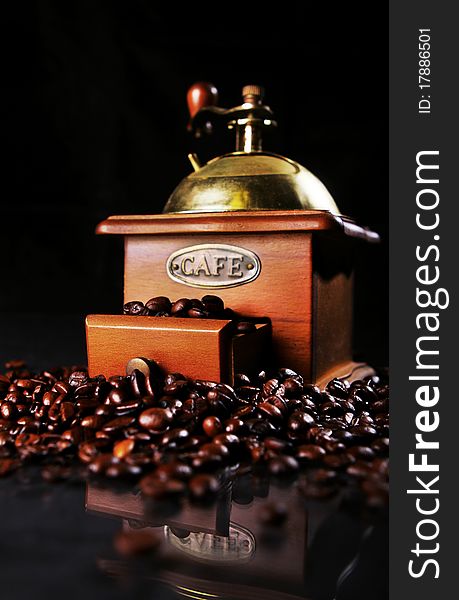 Coffee mill on the table with coffee beans around