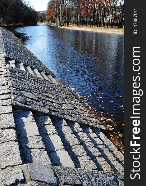 Autumn photo of stone river bank with stairs into water. Autumn photo of stone river bank with stairs into water.