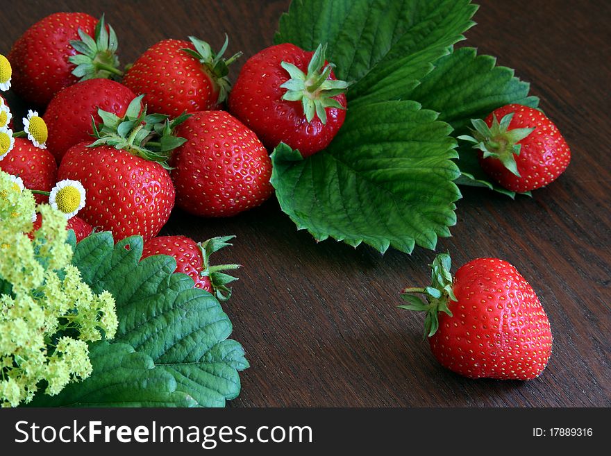 Strawberries arranged on a wooden table with some decoration