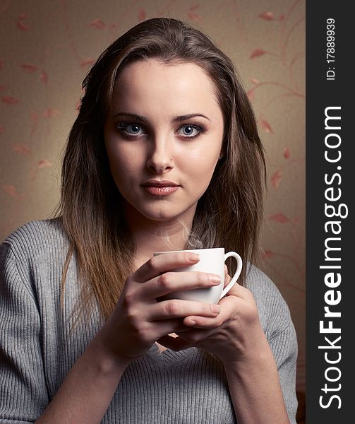 Beautiful young woman with cup of coffee