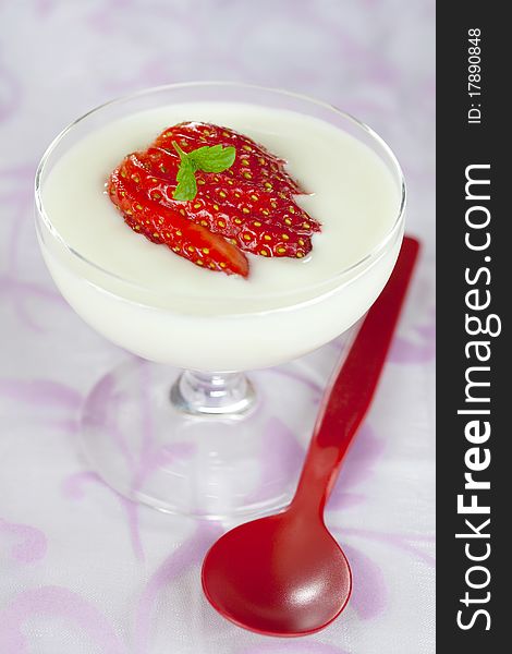 Fresh strawberry dessert in a glass with spoon