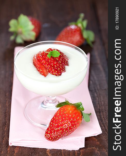 Fresh cream dessert with strawberry in a glass on napkin with fresh strawberries. Fresh cream dessert with strawberry in a glass on napkin with fresh strawberries