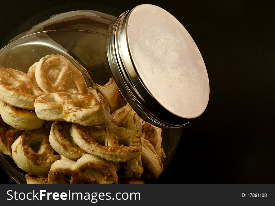 Pretzels in a glass jar with black background. Pretzels in a glass jar with black background