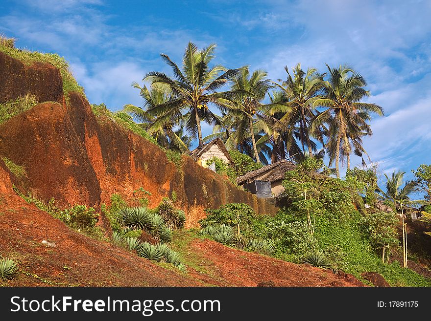 Tropical Huts On A Red Cliff