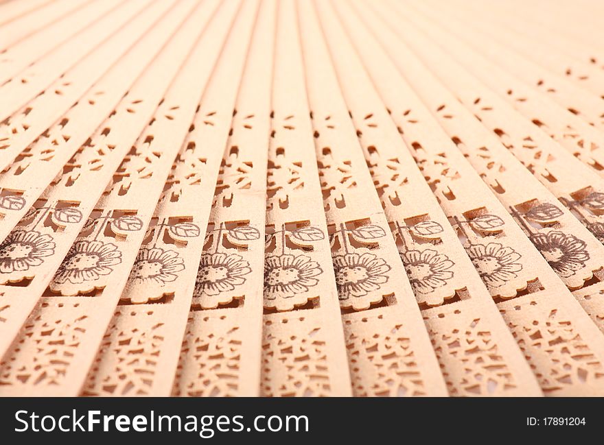 Macro shot of a fan with floral pattern; background